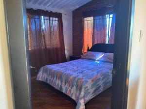 una camera con un letto in una stanza con finestre di Casa Montañita del RIO a Aratoca