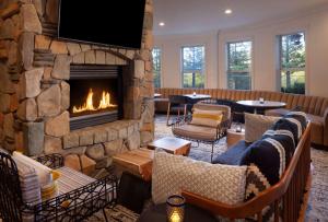 a living room with a fireplace and couches at Hilton Santa Cruz Scotts Valley in Santa Cruz