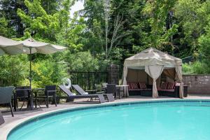 a swimming pool with chairs and a gazebo at Hilton Santa Cruz Scotts Valley in Santa Cruz