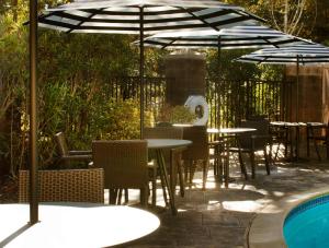 a patio with tables and chairs under an umbrella at Hilton Santa Cruz Scotts Valley in Santa Cruz