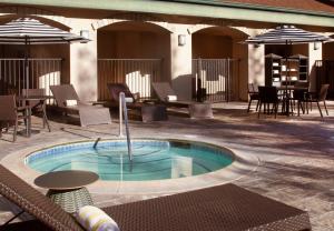 a hot tub in a patio with tables and chairs at Hilton Santa Cruz Scotts Valley in Santa Cruz