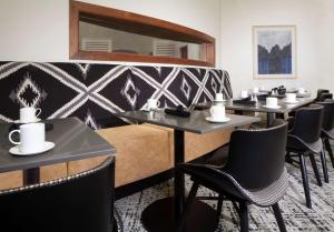 a restaurant with tables and chairs and a mirror at Hilton Santa Cruz Scotts Valley in Santa Cruz