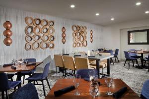 a dining room with tables and chairs and plates on the wall at Hilton Santa Cruz Scotts Valley in Santa Cruz