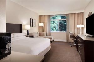 a hotel room with a white bed and a window at Hilton Santa Cruz Scotts Valley in Santa Cruz