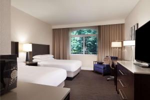 a hotel room with two beds and a tv at Hilton Santa Cruz Scotts Valley in Santa Cruz