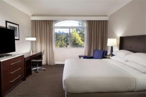 a hotel room with a bed and a desk and a window at Hilton Santa Cruz Scotts Valley in Santa Cruz