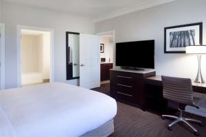 a hotel room with a bed and a desk with a television at Hilton Santa Cruz Scotts Valley in Santa Cruz