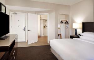 a hotel room with a white bed and a television at Hilton Santa Cruz Scotts Valley in Santa Cruz