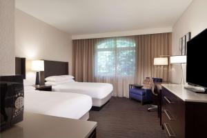 a hotel room with two beds and a tv at Hilton Santa Cruz Scotts Valley in Santa Cruz