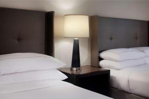 a hotel room with two beds and a lamp on a table at Hilton Santa Cruz Scotts Valley in Santa Cruz