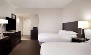 a hotel room with two beds and a flat screen tv at Hilton Santa Cruz Scotts Valley in Santa Cruz