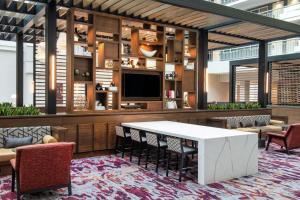 a lobby with a table and chairs and a tv at Embassy Suites by Hilton Walnut Creek in Walnut Creek