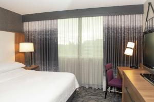 a hotel room with a bed and a television at Embassy Suites by Hilton Walnut Creek in Walnut Creek
