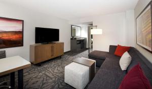a living room with a couch and a flat screen tv at Embassy Suites by Hilton Walnut Creek in Walnut Creek