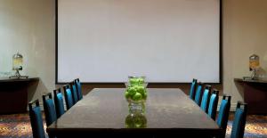 a table with a vase filled with green apples on it at Embassy Suites by Hilton Walnut Creek in Walnut Creek