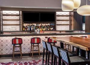 a bar with chairs and a wooden table at Embassy Suites by Hilton Walnut Creek in Walnut Creek