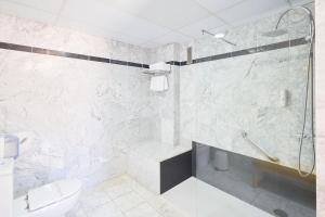 a white bathroom with a shower and a toilet at Hotel Torre Del Conde in San Sebastián de la Gomera