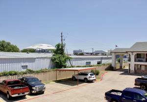 a parking lot with cars parked in front of a building at Executive Inn of Arlington, Near AT&T Stadium in Arlington