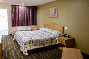 a hotel room with a bed and a window at Executive Inn of Arlington, Near AT&T Stadium in Arlington