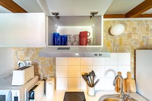 una cucina con lavandino e un armadio con utensili di Le Cocoon-4pers avec mezzanine-Cusset Villeurbanne a Villeurbanne