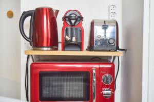 a red microwave with a toaster on top of it at Le Salengro - Studio cosy - métro Charpennes in Villeurbanne