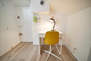 a yellow chair sitting at a desk with a lamp at Le Salengro - Studio cosy - métro Charpennes in Villeurbanne