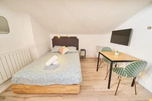 a bedroom with a bed and a desk and a table at Le Salengro - Studio cosy - métro Charpennes in Villeurbanne