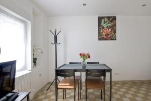 a dining room table with chairs and a vase of flowers at Charming house in Faches-Thumesnil - Welkeys in Faches-Thumesnil