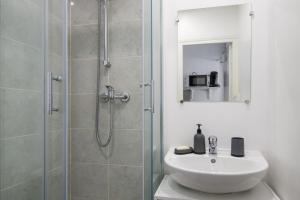 y baño con ducha, lavabo y espejo. en Charming house in Faches-Thumesnil - Welkeys en Faches-Thumesnil