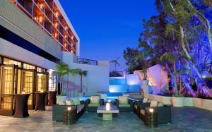 un patio dell'hotel con divani e tavoli di notte di Hilton Orange County/Costa Mesa a Costa Mesa