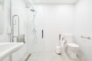 a white bathroom with a shower and a toilet at Hotel Torre Del Conde in San Sebastián de la Gomera