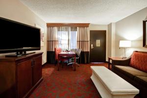 a hotel room with a couch and a television at Embassy Suites by Hilton Dulles Airport in Herndon