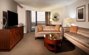 a living room with a couch and a television at Hilton Houston NASA Clear Lake in Seabrook