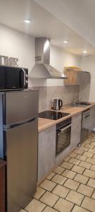 uma cozinha com electrodomésticos de aço inoxidável e balcões de madeira em meublé neuf avec jardin em Clairvaux-les-Lacs