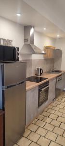 a kitchen with stainless steel appliances and wooden counters at meublé neuf avec jardin in Clairvaux-les-Lacs +5 photos