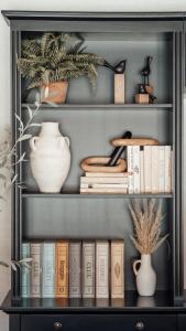 a book shelf with books and a vase and other items at Fireside Inn on Moonstone Beach in Cambria