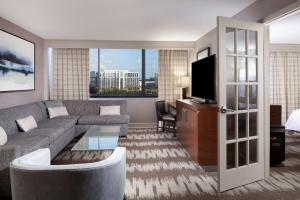 Hilton Tampa Airport Westshore في تامبا: غرفة معيشة بها أريكة وتلفزيون