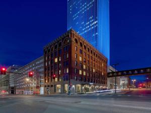 奥马哈The Peregrine Omaha Downtown Curio Collection By Hilton的夜晚街道拐角处的一栋建筑