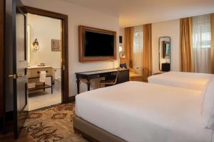 奥马哈The Peregrine Omaha Downtown Curio Collection By Hilton的配有床和书桌的酒店房间