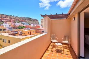 a balcony with chairs and a view of the city at Hotel Torre Del Conde in San Sebastián de la Gomera
