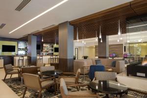 a lobby with tables and chairs and a bar at DoubleTree by Hilton Hotel Syracuse in East Syracuse