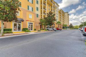 ulica miejska z żółtym budynkiem i zaparkowanymi samochodami w obiekcie Elegant Condo Retreat Near Disney w Orlando