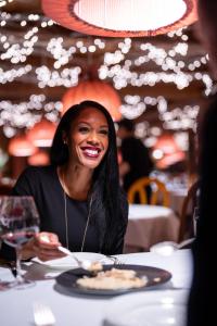 a woman sitting at a table with a plate of food at Post Hotel & Spa in Lake Louise