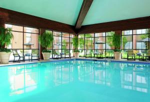 a large swimming pool in a building with windows at DoubleTree by Hilton Hotel Syracuse in East Syracuse