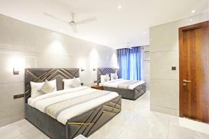 a hotel room with two beds and a door at Frankstay By Hotel Preet in 05 mints walking Distance Nizamuddin Railway Station in New Delhi