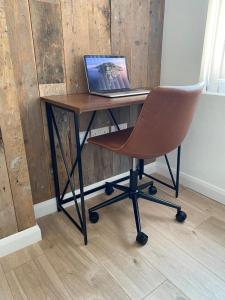 a desk with a chair and a laptop computer on it at The Old Warehouse in Blackpool