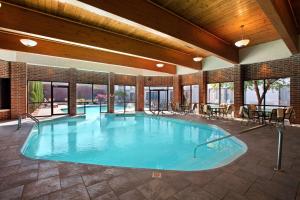 a large pool in a building with tables and chairs at DoubleTree by Hilton Hotel Cleveland - Independence in Independence