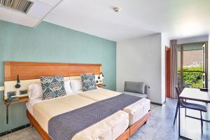 a bedroom with a large bed and a chair at Hotel Torre Del Conde in San Sebastián de la Gomera