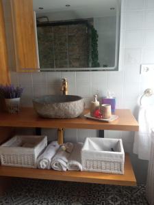 a bathroom with a sink and towels on a shelf at O Noso Lar - RIBEIRA SACRA in Nogueira de Ramuin +21 photos