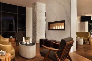 Embassy Suites By Hilton Boulder في بولدر: غرفة معيشة مع كراسي ومدفأة